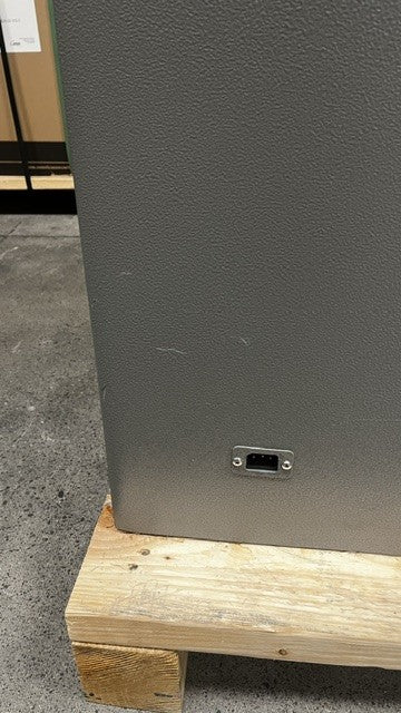 View of small scratches on the paint on the back of the safe and view of the power source in the back. 