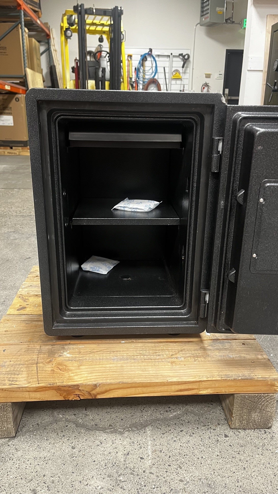 View of the inside of the safe. The safe comes with one adjustable shelf and one removable tray on the top. The safe also has one predrilled hole to bolt down the safe. 