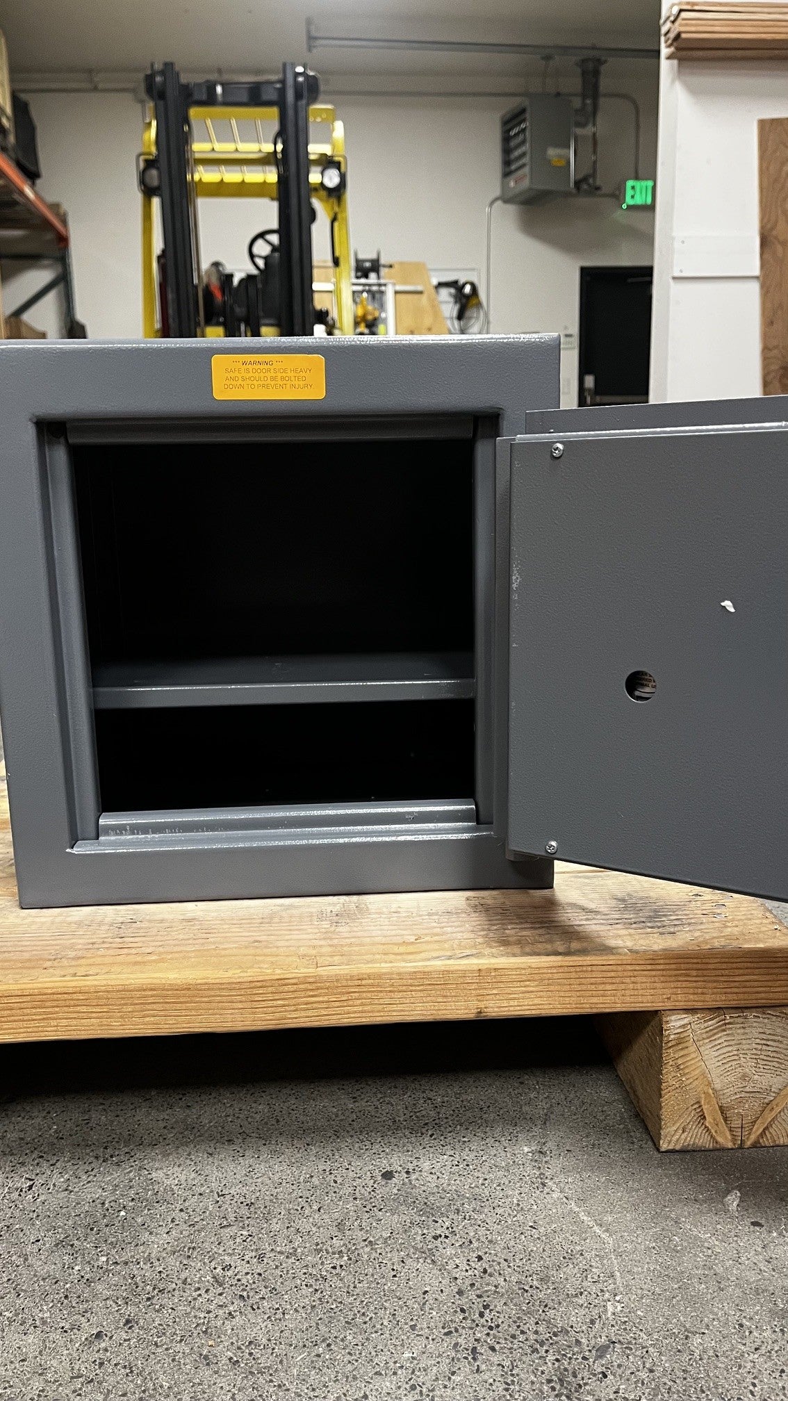 View of the inside of the safe. The safe comes with one adjustable shelf. The door has some paint chip on it.