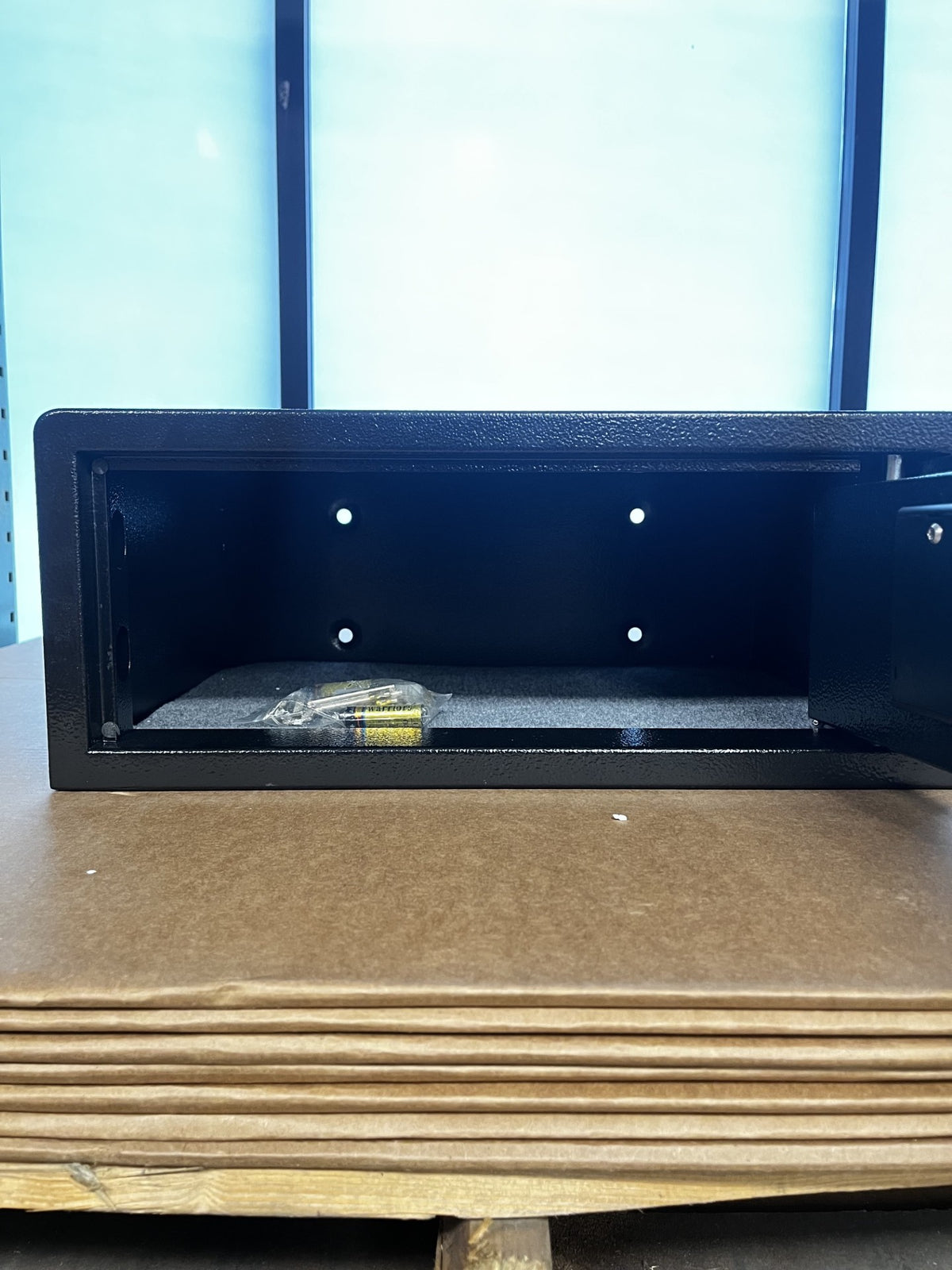 View of the inside of the safe. It comes with the mount hardware, backup keys, and batteries.  