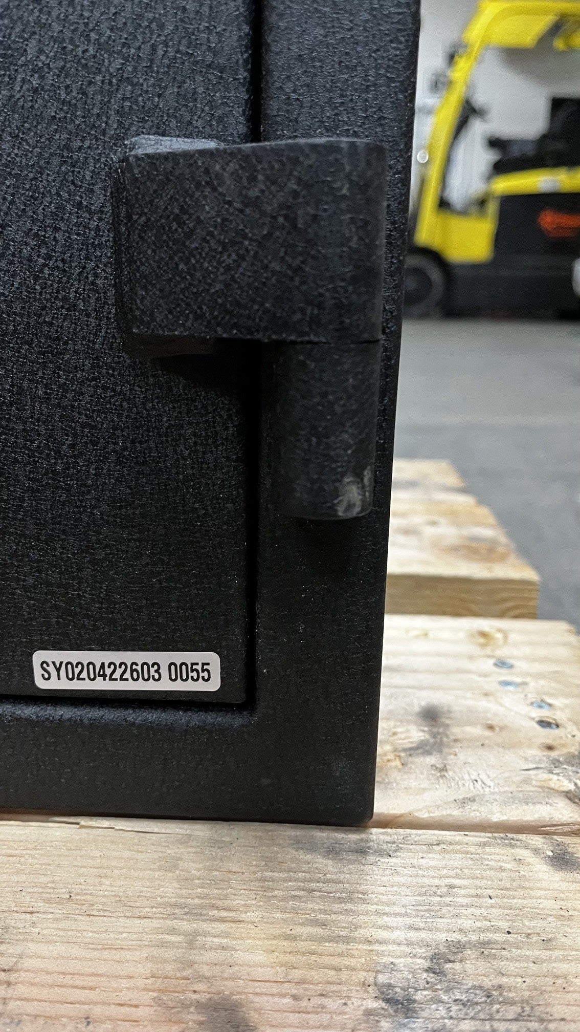 View of the bottom lower hinge. The hinge has a small scratch on it. 