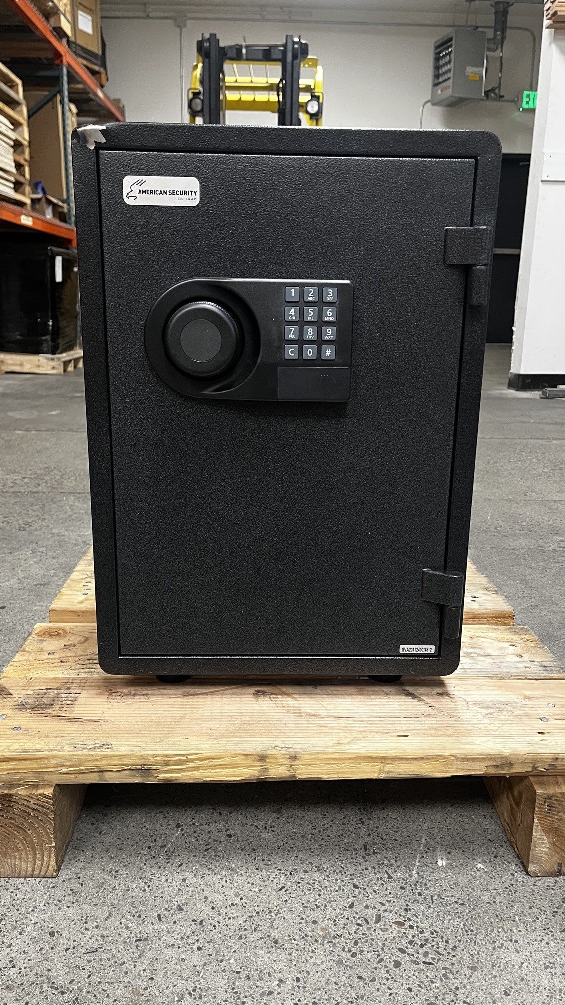 Front view of the safe. The top left corner has a large chip on the paint. The safe has a digital lock. 