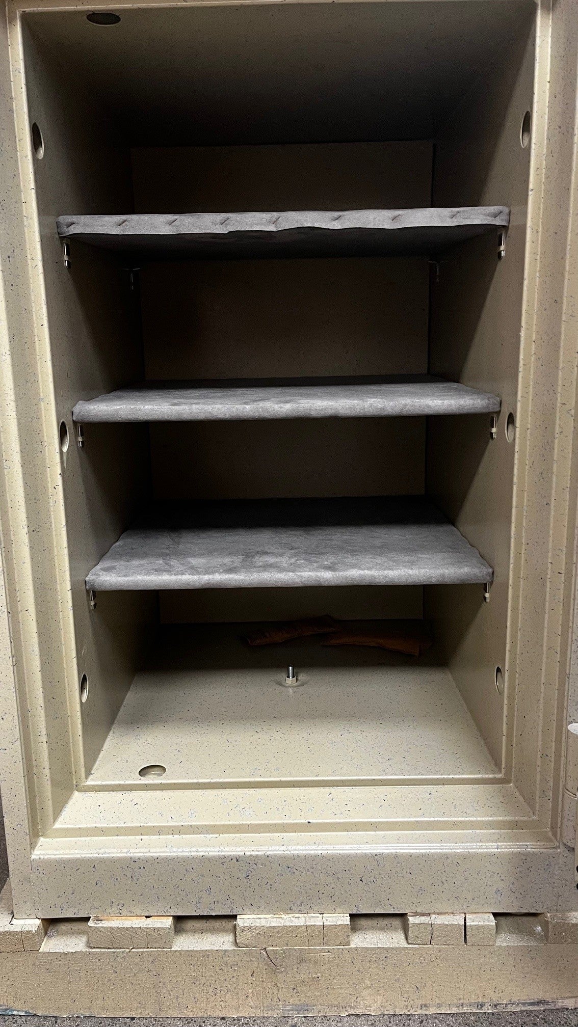 View of the inside of the safe. It comes with three shelves and one center bolt down hole. 