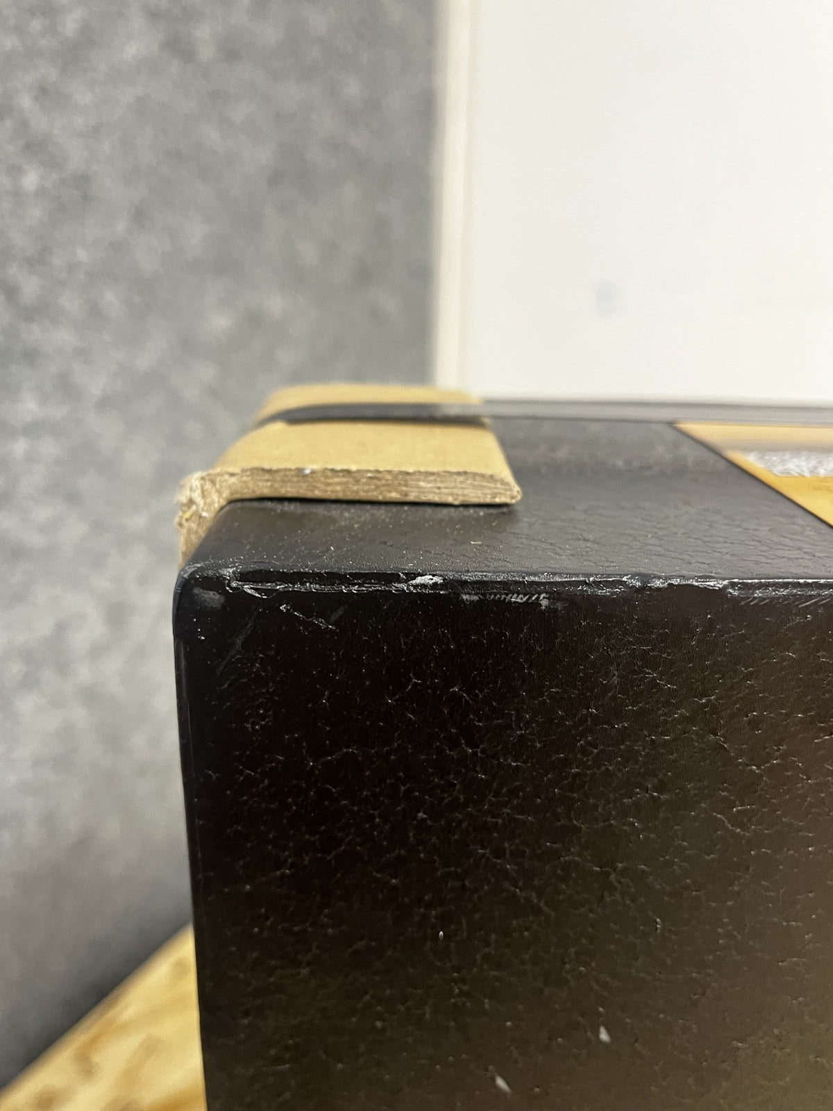 View of chips on the paint on the top left corner of the safe. 