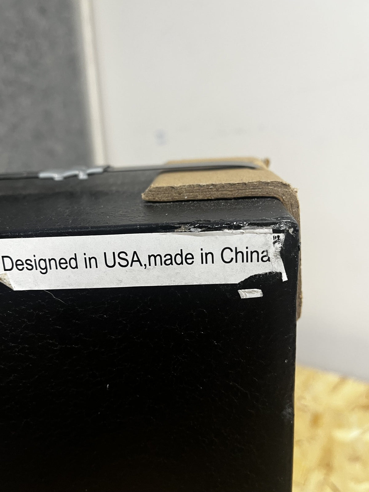 Close up view of some chips on the paint on the back top right corner of the safe. 