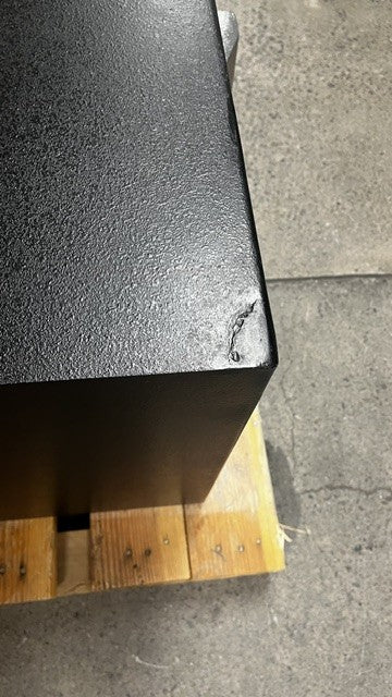 View of the top left corner where the safe was damaged but has been fixed and painted black to match the color of the safe. 
