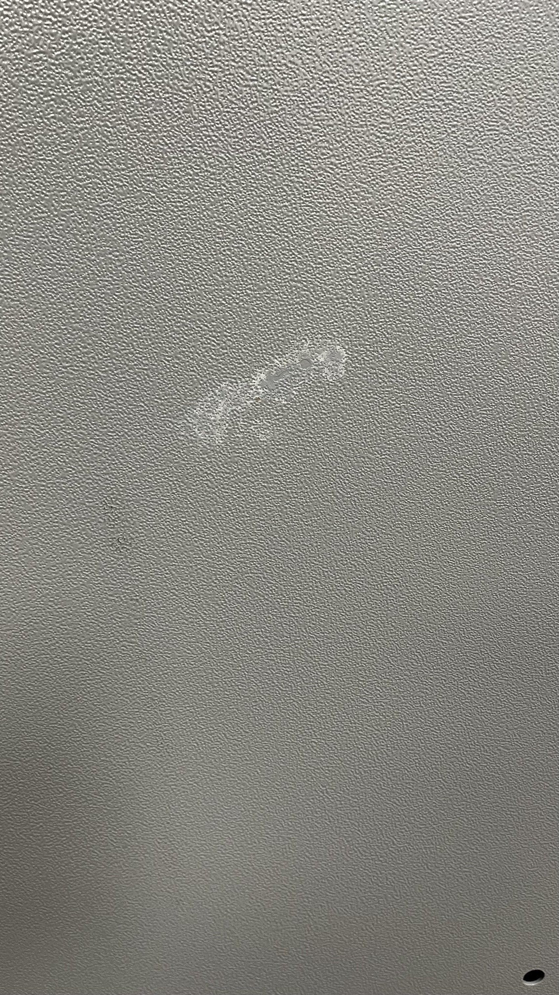 Close-up view of the scratch on the back of the safe. The scratch has been touched up with paint. 