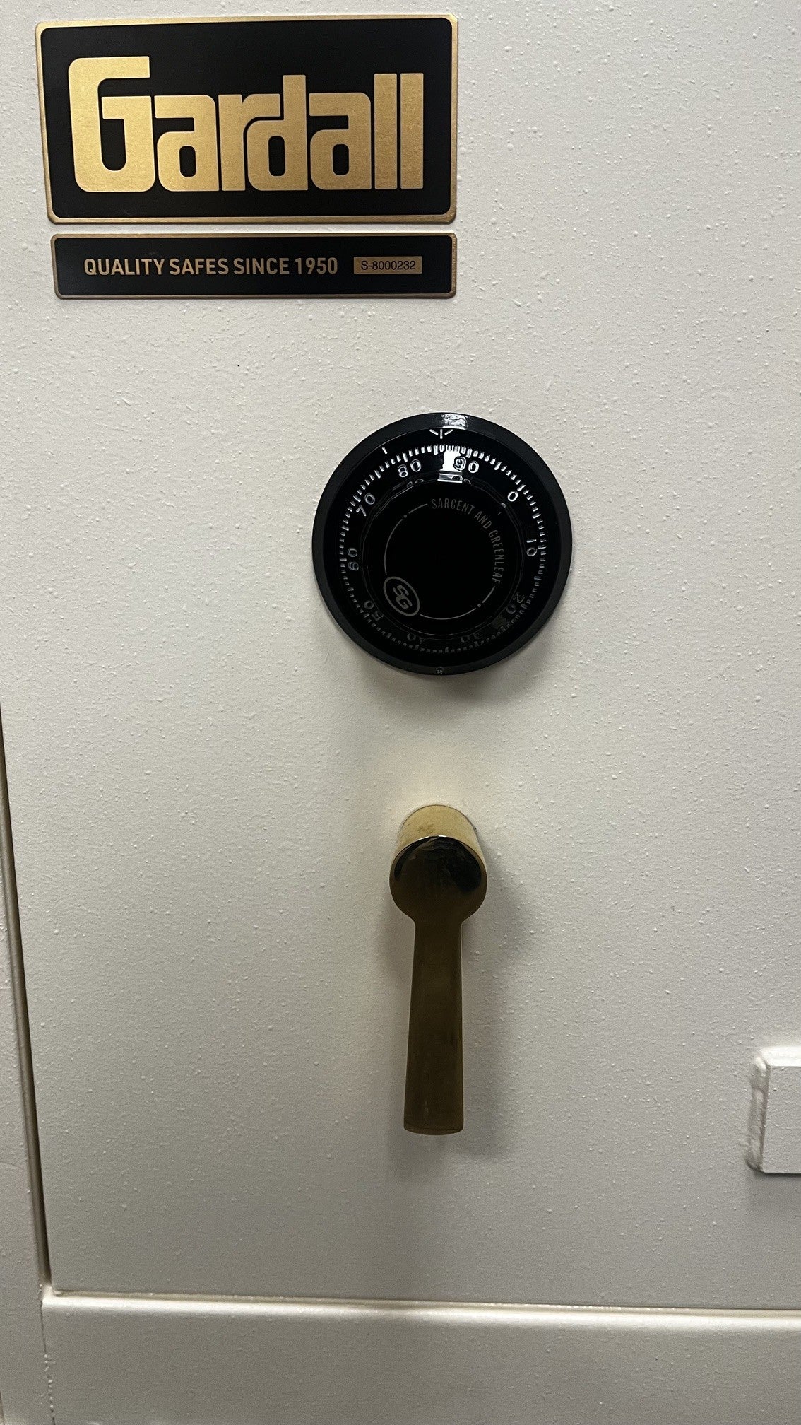 Close-up view of the S&G dial combination lock and gold L shape handle. 