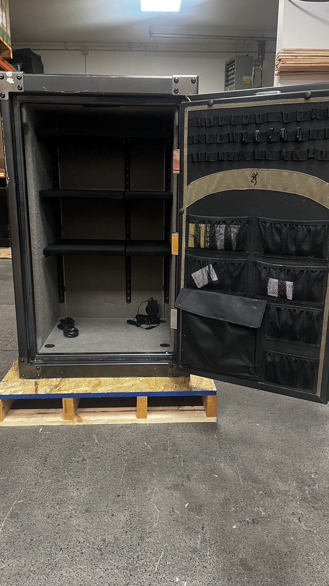 View of the inside of the safe. It has six adjustable shelves. A power outlet in the right bottom of the safe and a light kit. The door has a document bag. 