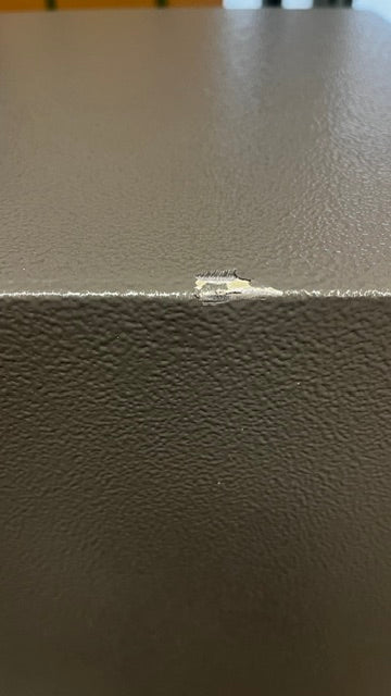 View of paint chip on the top of the edge of the safe. 