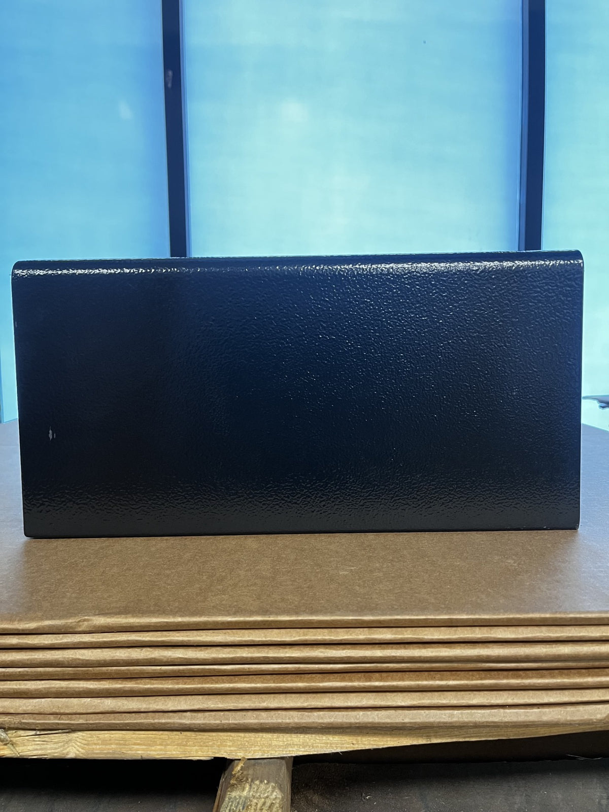 View of the left side of the safe. It has a small scratch on the paint. 