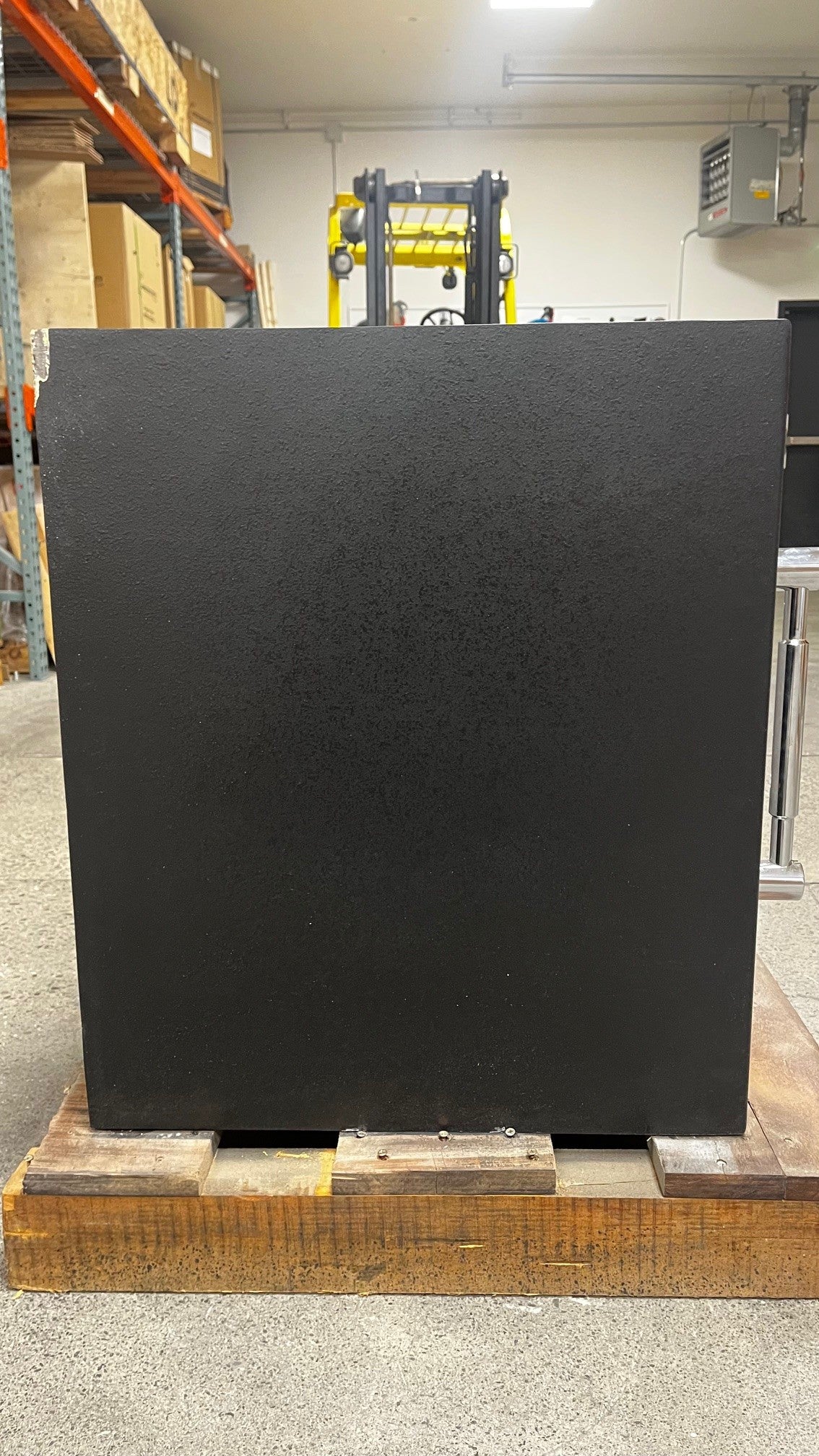 Left side view of the safe. The top left corner has chips on the paint. 