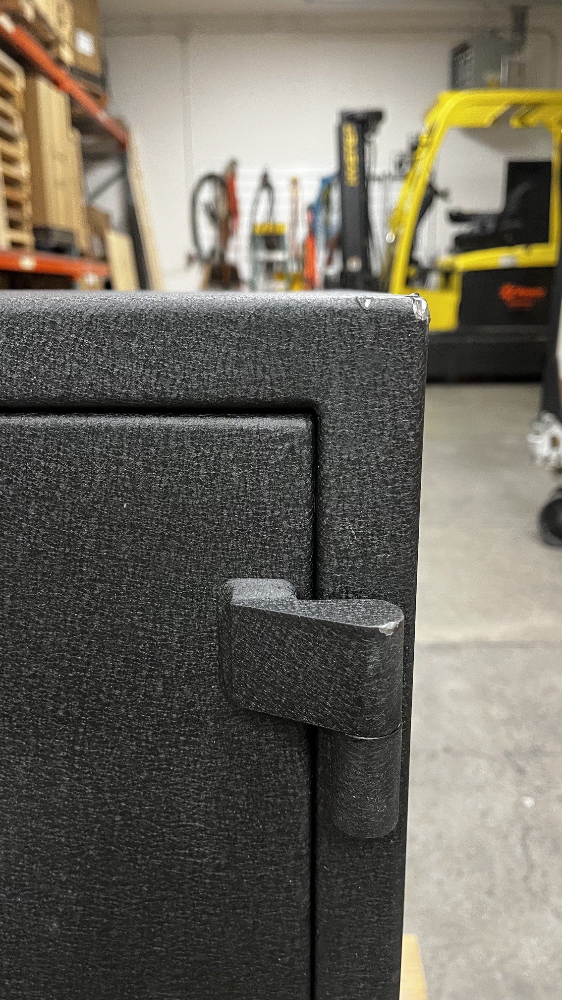 Close-up view of the top right corner. The corner has a chip on the paint. Also, the top area of the hinge has a small chip on the paint. 