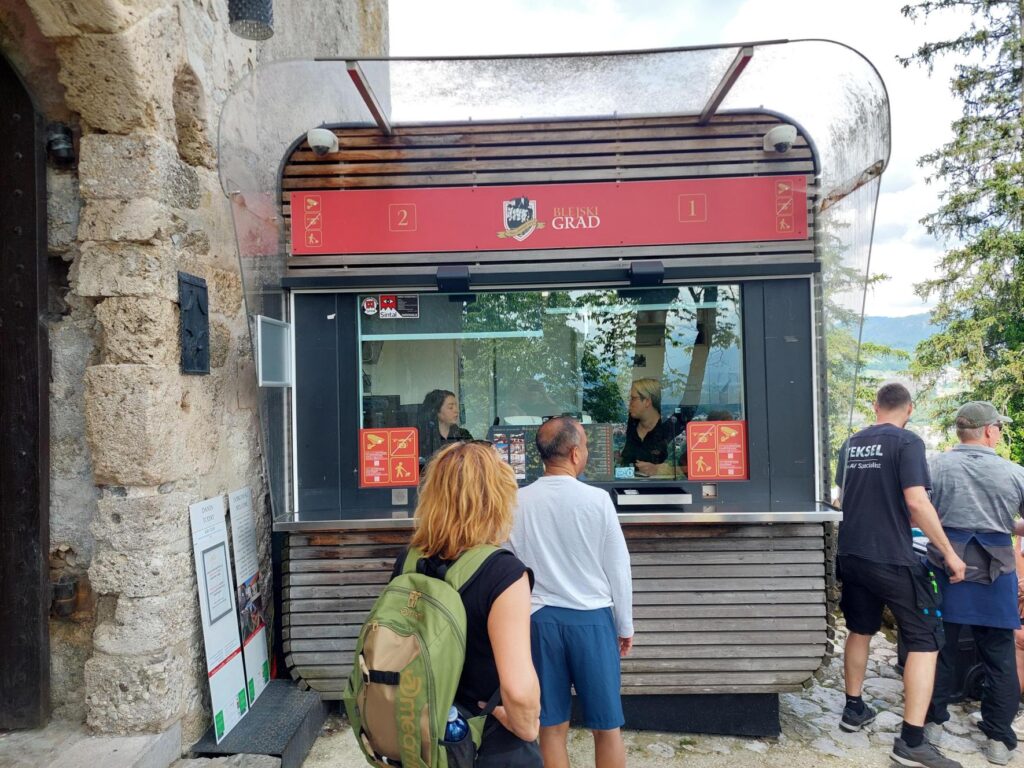 Contacta STS-K080-IP installed at a busy outdoor ticket booth with customers lined up at two service windows