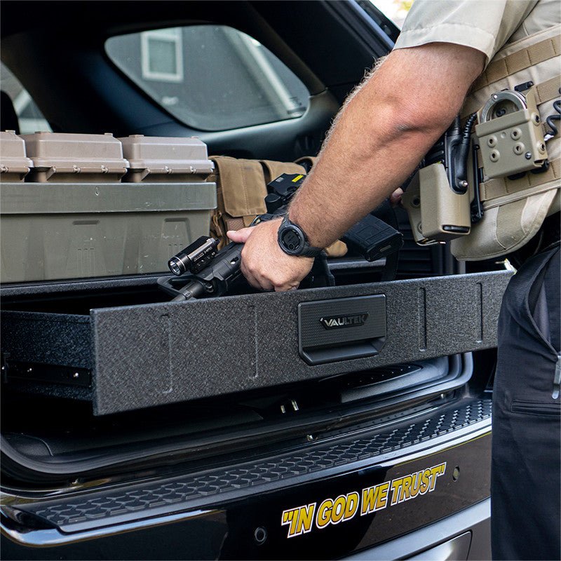 Law enforcement officer accessing the Vaultek SLV200i from the back of a patrol vehicle with duty gear visible