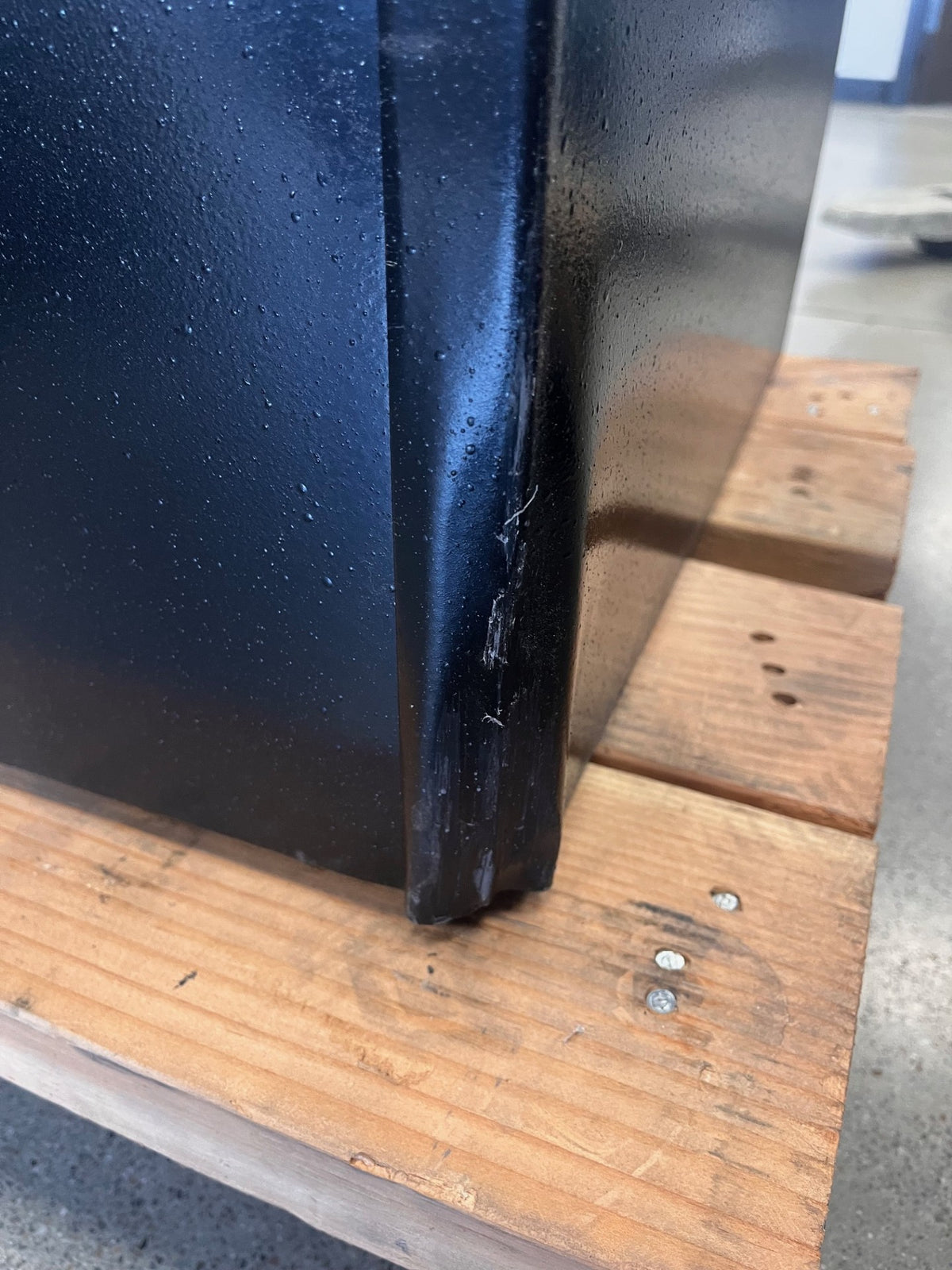 Lower back right corner. The safe has a dent on the corner and scratches on the paint. 