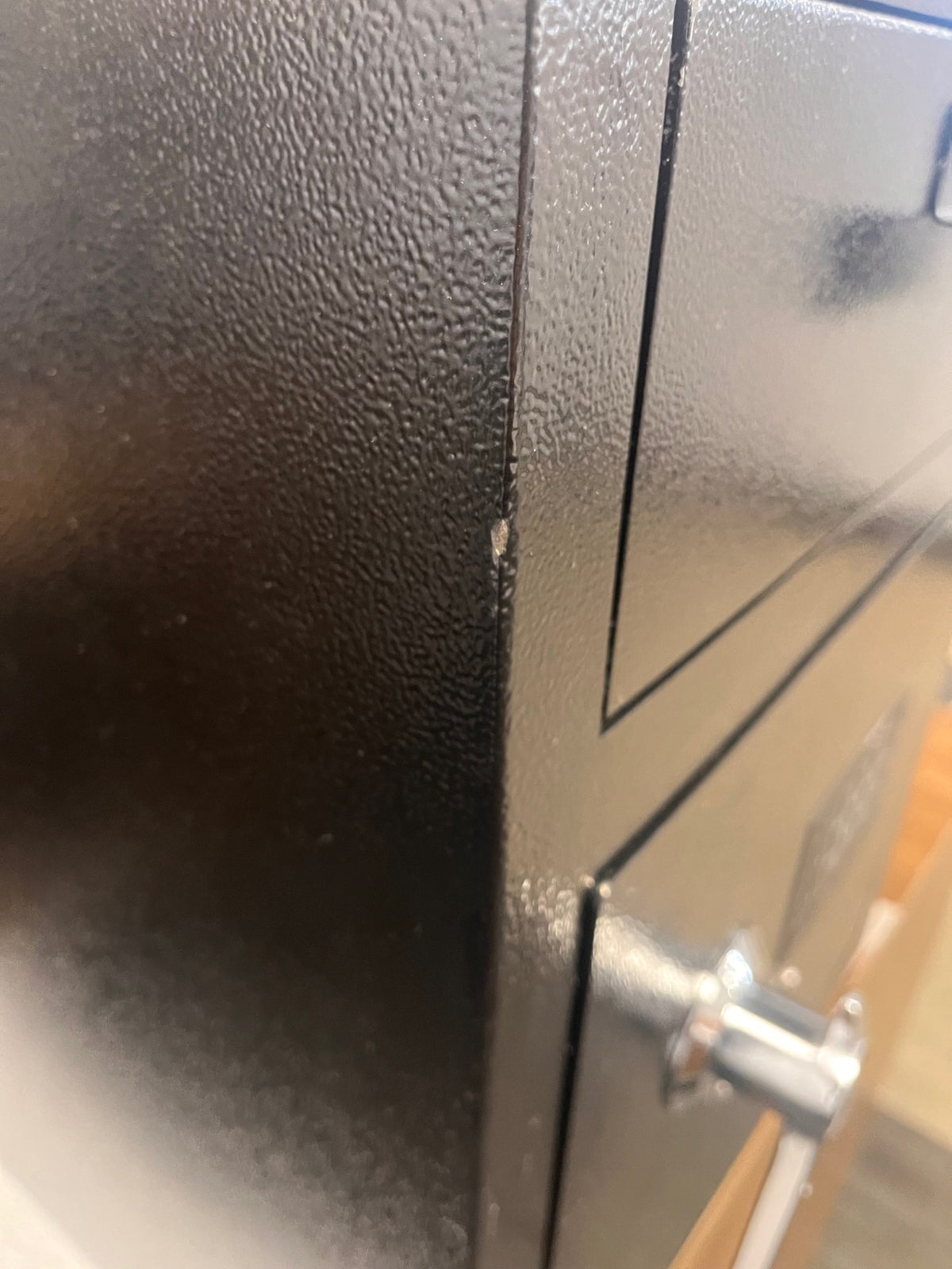 Close-up of the front left edge where a scratch/chip on the paint is visible. 