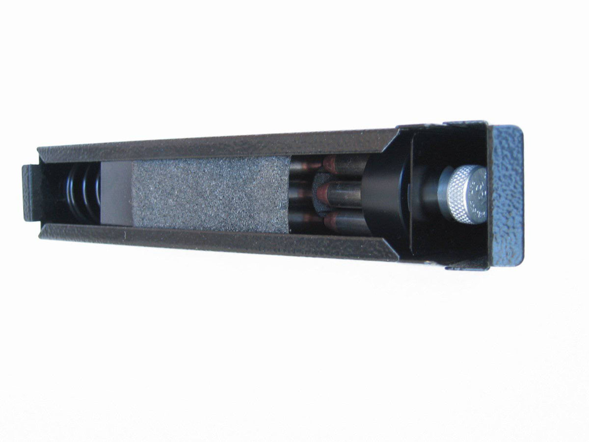 Titan A-Box side profile view with cover partially open, showing the interior compartment filled with pistol cartridges cushioned by foam padding and the knurled silver locking knob at one end