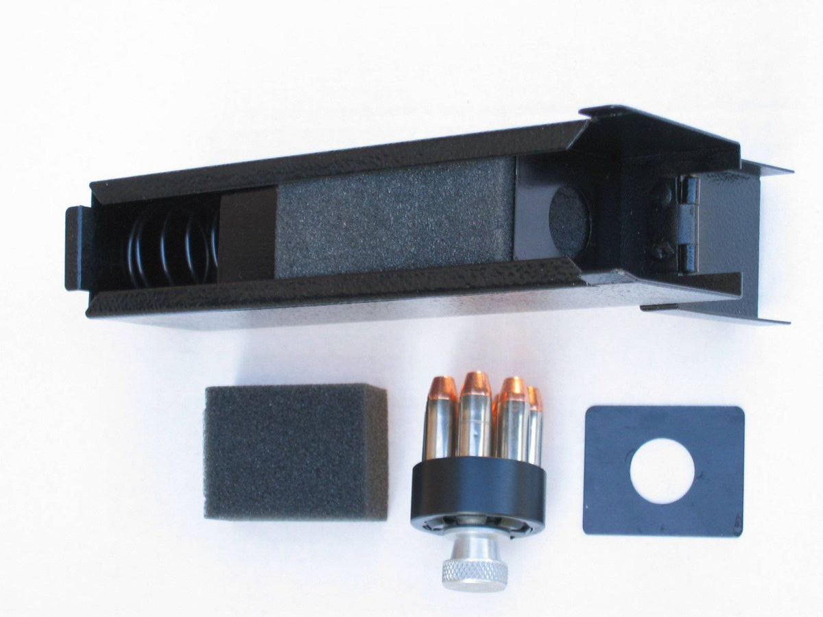 Titan A-Box in black shown from above with interior compartment open, revealing foam padding and internal retention spring, with a loaded revolver speed loader, foam insert pad, and mounting plate laid out beside it